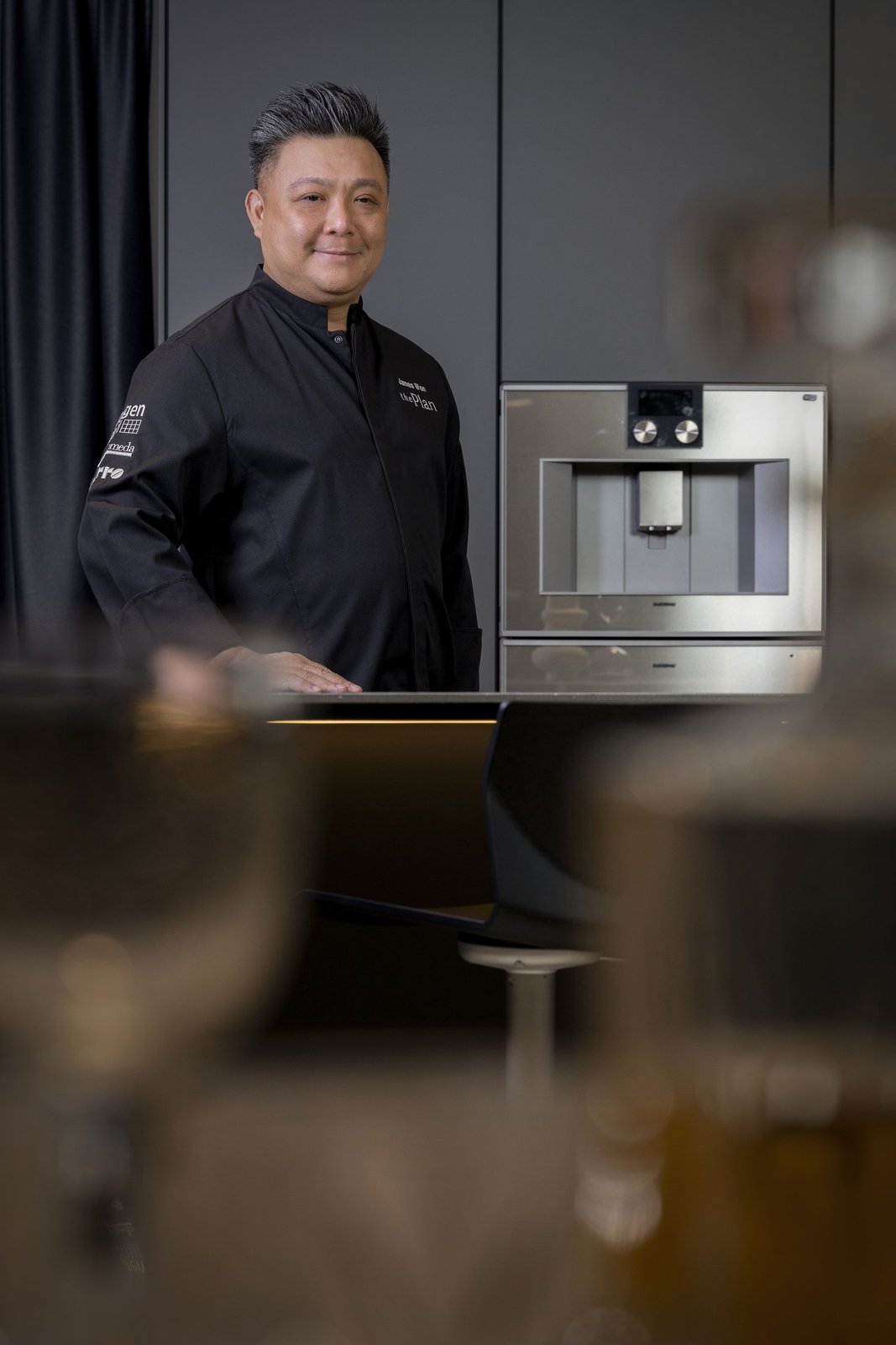 James Won in The Plan jacket beside the Gaggenau 400 Series built-in stainless steel appliance at the atelier showroom.