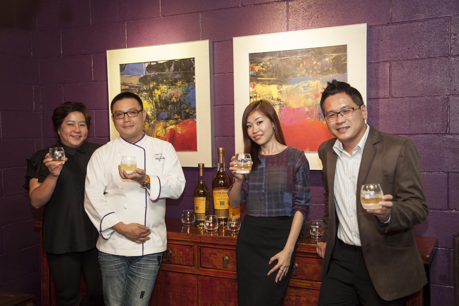 James Won with the Glenmorangie Maison and Moet Hennessy Diageo Malaysia counterparts at Brasserie Enfin, August 2014 — Glenmorangie Original and 18 Year Old bottles between them, abstract artwork on the purple wall behind.