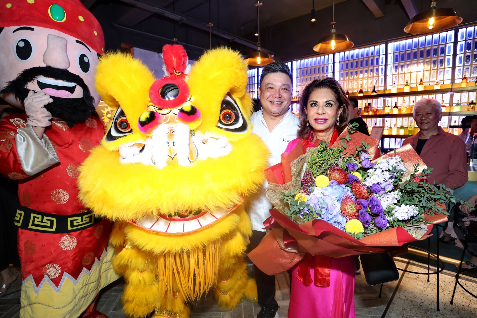James Won with HRH Sultanah Kalsom at the grand opening of MeatMore, a lion dancer beside them.