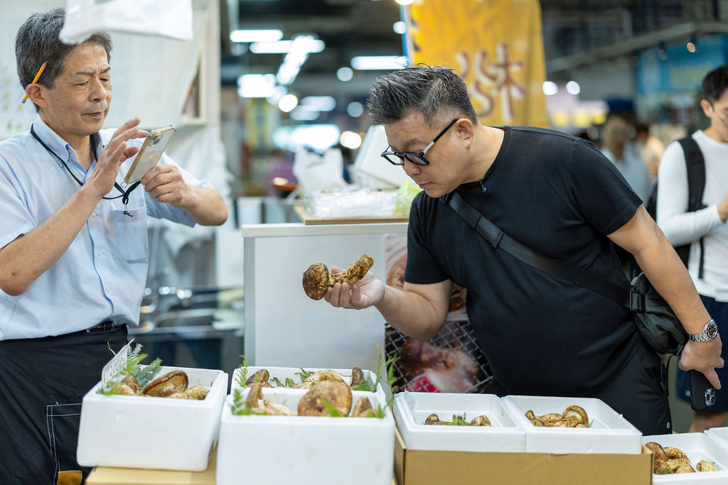 Examining produce with a trader in an Osaka market