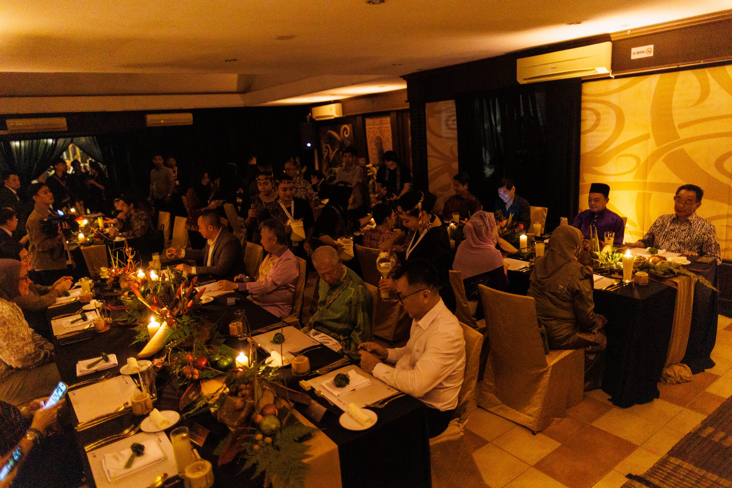 Guests at long candlelit tables in the dining room