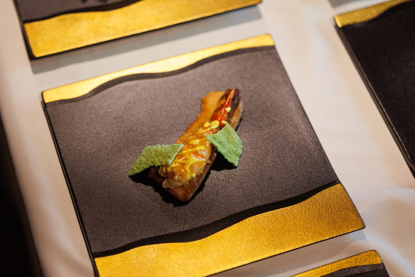 A course served on a black and gold plate