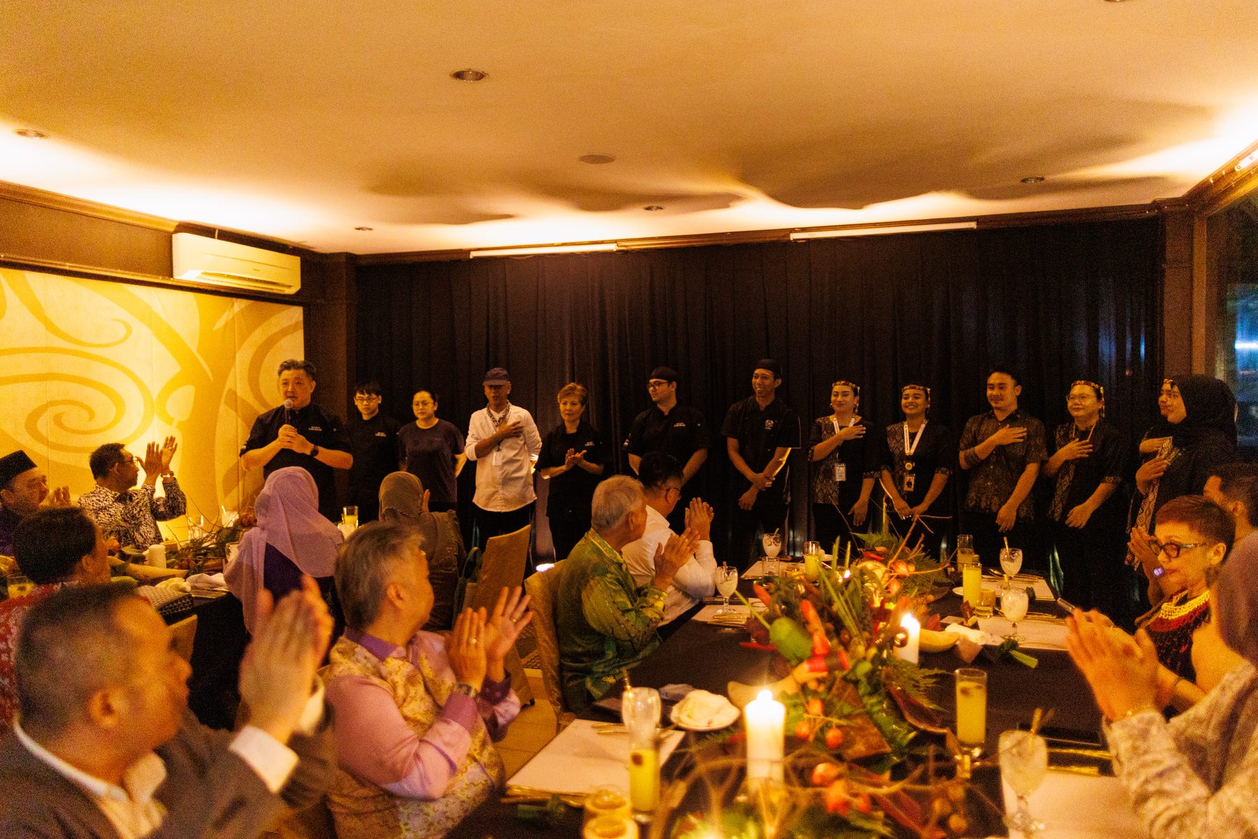 Guests applauding the kitchen team at the close of the evening