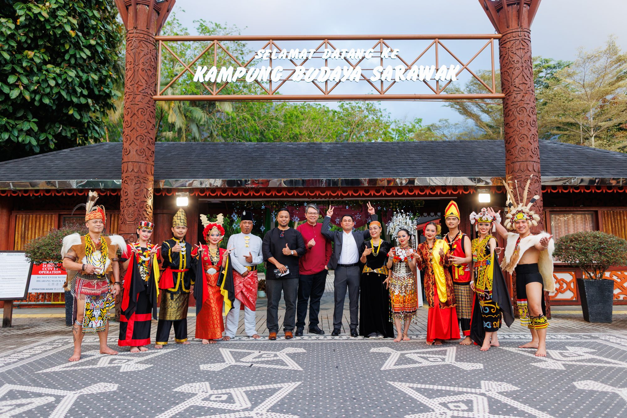 Performers in the dress of Sarawak's communities at the gate of Sarawak Cultural Village